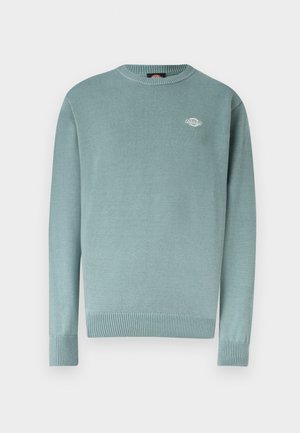 Ανοιχτό μπλε πουλόβερ με στρογγυλή λαιμόκοψη και ριμπ μανσέτες και τελείωμα, με ένα μικρό λευκό λογότυπο στο αριστερό στήθος.