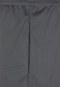 Dunkelgraue Sportshorts aus atmungsaktivem Netzstoff, mit einer gepunkteten Textur und einem geraden Schnitt mit zentraler Naht.