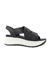 Sandalo con zeppa in pelle nera, design con cinturino incrociato e punta aperta. La suola intermedia bianca e la suola esterna nera texturizzata migliorano supporto e stile.