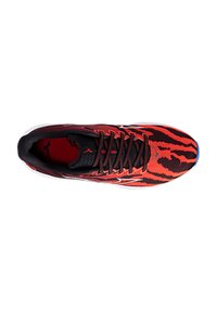 Roter und schwarzer Sportschuh mit strukturiertem Obermaterial, das ein Tigerstreifenmuster aufweist, schwarzen Schnürsenkeln und einer weißen Sohle.