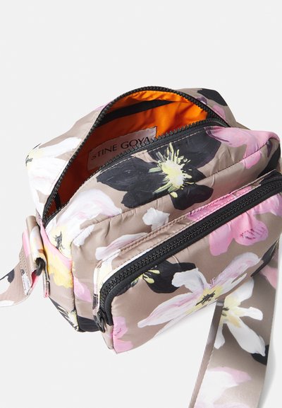 Borsa a tracolla floreale in morbido tessuto; presenta fiori rosa, neri e bianchi su uno sfondo beige. L'interno è arancione con chiusura a zip.