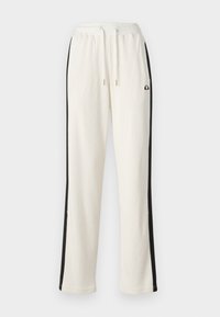 Cremefarbene Sweatpants mit schwarzen Seitenstreifen, elastischem Bund mit Kordelzug, strukturiertem Rippstoff und Logo an der oberen Seite.
