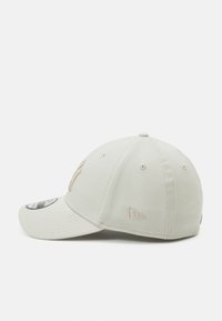 Casquette de baseball grise avec une visière incurvée, ornée d'un logo brodé beige, à six panneaux et dotée d'œillets d'aération pour la respirabilité.