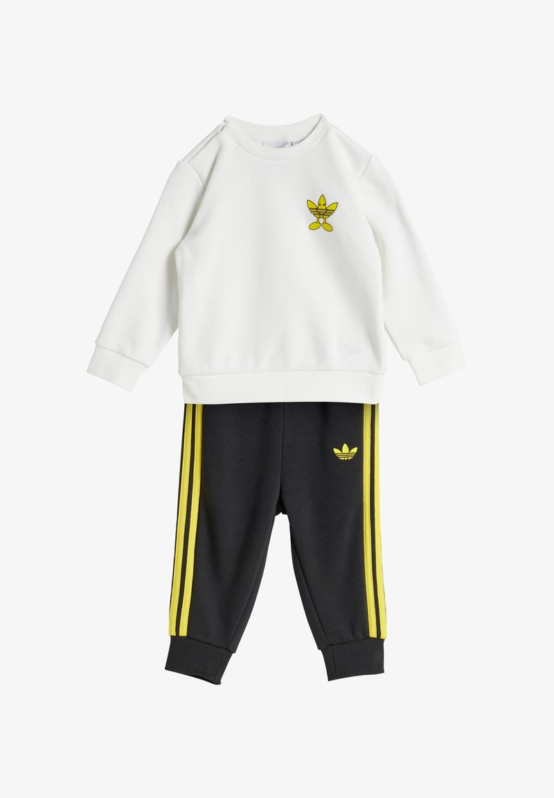 White sweatshirt with yellow cartoon logo on front, paired with dark gray pants featuring yellow side stripes and logo on hip.