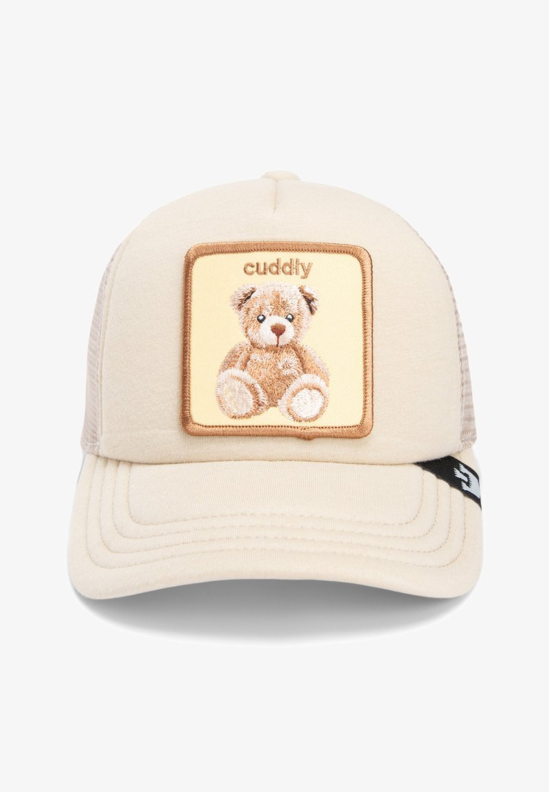 Gorra de camionero color marrón claro con un parche bordado marrón que presenta un oso de peluche. Parte trasera de malla, visera curva y un pequeño acento negro en el lado.