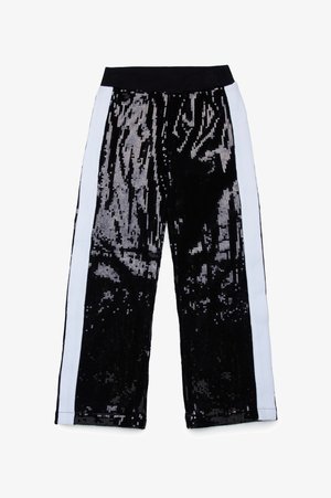 Sorte paljetterbukser med vid ben, med hvite sidestriper. Stoffet har et skinnende, teksturert utseende skapt av paljettene.