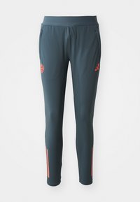 Pantalon de sport gris foncé avec une taille élastique, doté d'accents rouges sur les côtés et d'un petit logo sur la cuisse supérieure. Matériau doux.