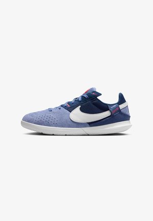 Blue suede and mesh athletic shoe with white logo, textured accents, navy laces, and rubber outsole. Side profile view.