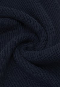 Tissu côtelé bleu marine avec une texture lisse, présentant des lignes horizontales et une tombée douce, idéal pour la chaleur et le confort.