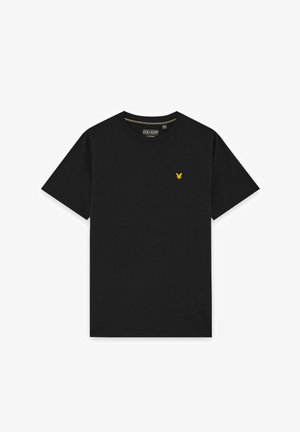 T-shirt noir à manches courtes et col rond avec petit logo d’oiseau jaune sur la poitrine gauche et étiquette de marque à l’intérieur du col.