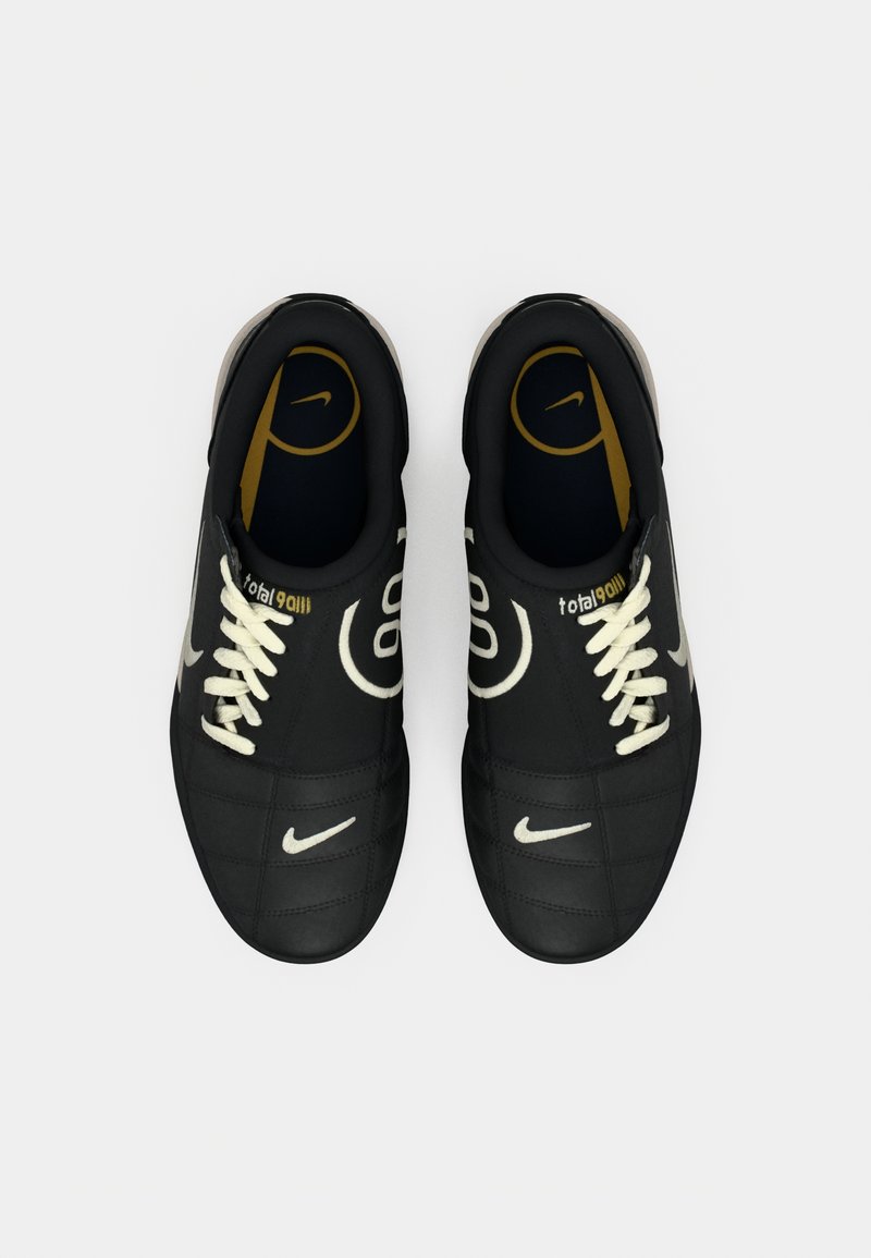 Par de zapatos de fútbol Nike Total 90 negros con cordones y logotipos blancos, vistos desde arriba sobre un fondo blanco.