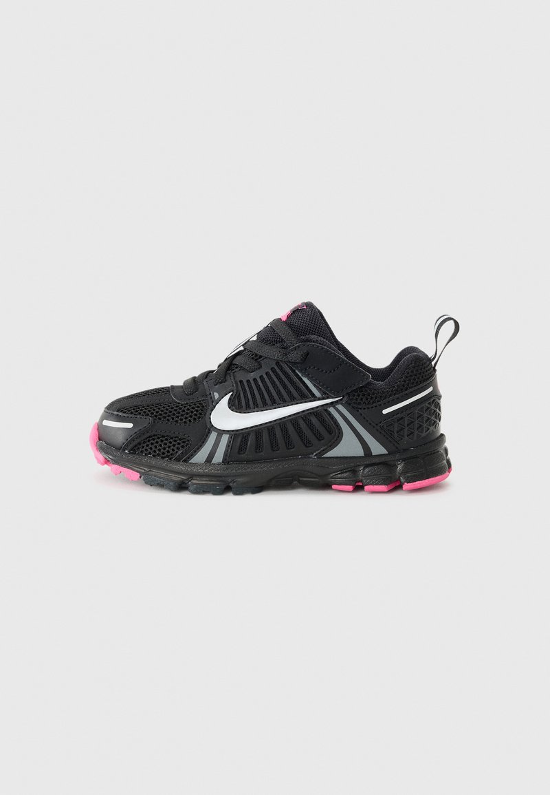 Scarpa sportiva nera con tessuto in rete, dettagli argentati, suola in gomma rosa e una sicura fascia in Velcro. Motivi testurizzati sui lati.
