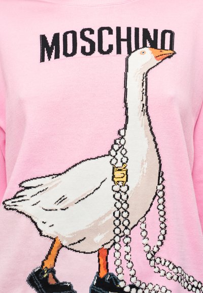 Pull rose clair avec un graphisme d'une oie portant des chaussures noires et drapée de colliers de perles, avec la marque "MOSCHINO" au-dessus.