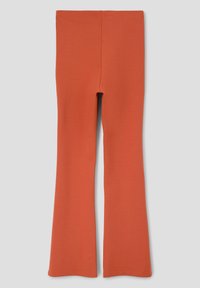 Flared leggings in een effen roestoranje kleur. Gemaakt van rekbare stof met een gladde textuur. Heeft een hoge tailleband en een aansluitend ontwerp.
