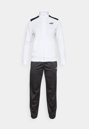 Chaqueta blanca de Puma con cremallera completa y paneles de hombro negros, combinada con pantalones de chándal negros de Puma, sobre un fondo sencillo.