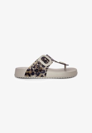Sandalia beige con suela gruesa, tira con estampado de leopardo, hebilla grande y separador para el dedo, mostrada de perfil sobre fondo blanco.