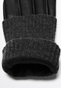 Zwarte leren handschoenen met een donkergrijze geribbelde gebreide boord. Het leer heeft een gladde afwerking, terwijl de boord een zacht, gestructureerd patroon heeft.