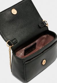 Schwarze, genarbte Lederhandtasche mit metallischem Druckverschluss, Kettenriemen und einem pinkfarbenen, gemusterten Innenraum. Mit einem Logofähnchen im Inneren.