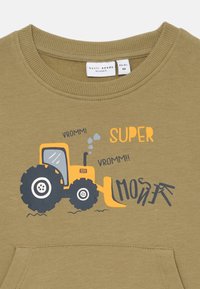 Felpa verde oliva con una grafica di un trattore in giallo e blu navy. Presenta il testo "SUPER VROMM!!" e "MOSER" in caratteri giocosi.