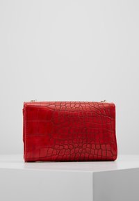 Clutch bag in ecopelle rossa con texture a coccodrillo, finitura liscia, forma rettangolare e chiusura a zip nella parte superiore.