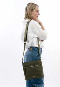 Green nylon shoulder bag with adjustable strap, flat rectangular shape, front zipper pocket, smooth texture, and silver hardware accents.