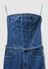 Salopette in denim con scollo aderente, spalline regolabili, chiusura a bottoni e cintura in vita. Presenta due tasche laterali e cuciture blu.