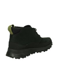 Botas de senderismo negras con un acabado liso, diseño ligero, tirador verde y suela de goma texturizada para tracción.