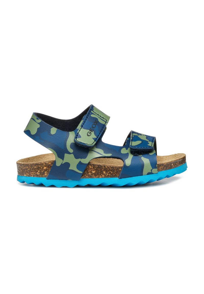 Sandalias de camuflaje en azul y verde con dos correas de velcro ajustables, plantilla de corcho y suela texturizada en azul. Diseño casual y ligero.