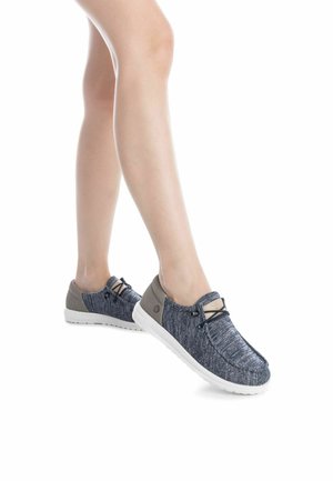 Zapatos slip-on de punto azul con acentos grises, cordones elásticos y suelas de goma blanca. Presentan un acabado texturizado y un diseño de punta redonda.