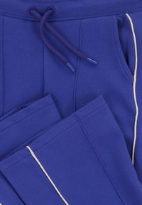 Blauwe trainingsbroek met witte zijpiping, voorzakken en een paarse trekkoord in de taille.