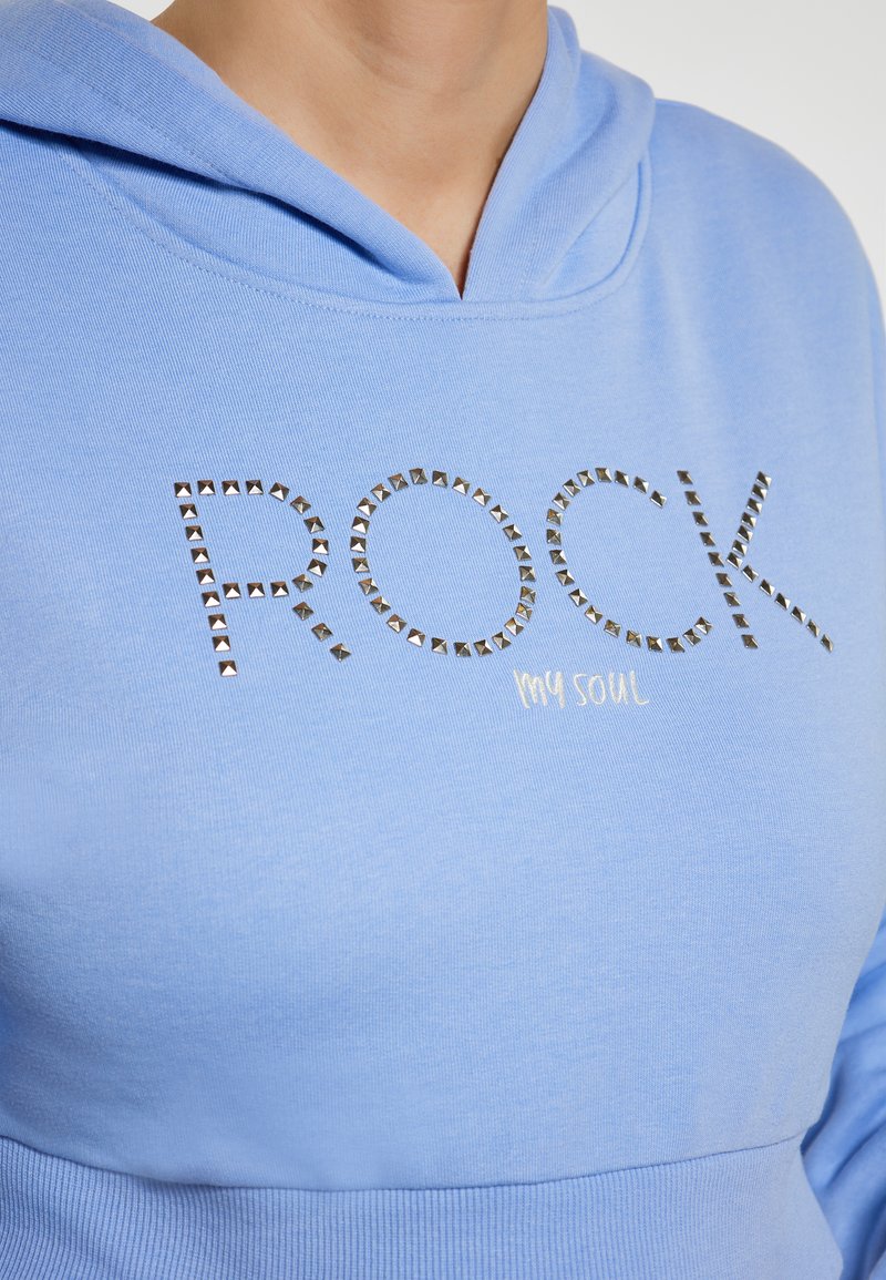 Felpa azzurra chiara con tasca a marsupio. Caratterizzata da "ROCK" in lettere argentate con borchie e "my soul" in bianco, realizzata in tessuto morbido e testurizzato.