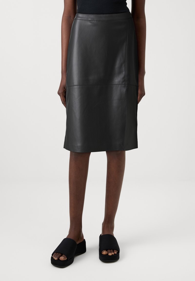 Zwarte leren kokerrok met een gladde textuur, middenlange ontwerp en minimale stikdetails, gecombineerd met zwarte instap sandalen.