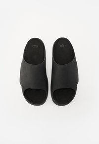 Sandali neri senza fibbia con tomaia in pelle liscia e morbida fodera interna testurizzata. Design open toe. Stile minimalista senza ulteriori dettagli.