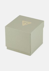 Ruudukujuline oliivroheline tekstuuriga karp, mille pealmises keskes on prinditud kuldne Guessi logo kolmnurk, suletud eraldi kaanega.