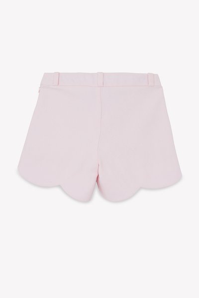 Ροζ σορτς με κυματιστό τελείωμα, κατασκευασμένα από υφασμάτινη υφή, με λείο ζωνάρι μέσης και διακριτικό φερμουάρ στο πίσω μέρος. Δεν φαίνονται τσέπες.