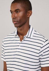 Polo a maniche corte con righe orizzontali blu navy e bianche, con patta a bottoni e colletto classico realizzato in un tessuto texture.