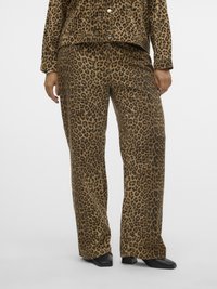 Pantaloni a gamba larga con stampa leopardata marrone e nera abbinati a una giacca coordinata, indossati con scarpe nere con punta quadrata.