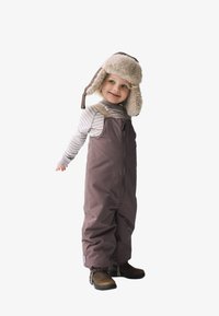 Overoles de invierno marrones con cremallera frontal, puños elásticos y tirantes ajustables, combinados con un gorro de piel de imitación en color beige y camisa de manga larga a rayas.