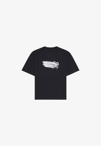 T-shirt en coton noir avec un col rond et des manches courtes. Présente un design de coup de pinceau blanc et du texte de marque au dos.