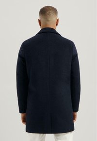 Marineblauwe wollen jas met een rechte snit, voorzien van een geknipt kraag en lange mouwen, met een gladde textuur en off-white accenten aan de zoom.