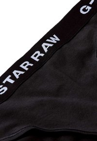Čierne boxerky s mäkkou textúrou a širokým elastickým pásom s nápisom "G-STAR RAW" v bielej farbe. Hladká textúra, priliehavý strih.