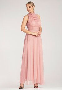 Maxi sukienka z delikatnego różowego szyfonu z wysokim dekoltem i plisowanym przodem. Przezroczysta spódnica nakłada się na dopasowaną podszewkę, tworząc zwiewny, elegancki kształt.