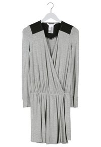 Robe portefeuille grise à manches longues, avec des accents noirs aux épaules et un col texturé. La jupe est froncée à la taille pour un effet évasé.