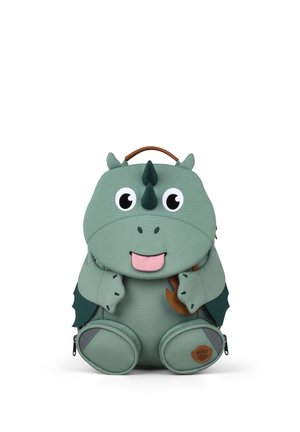 Green dinosaur-shaped backpack with big eyes, two horns, wings, and a pink tongue sticking out, designed for children.