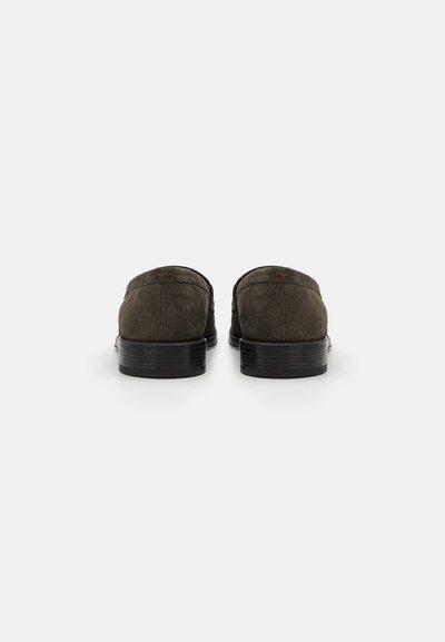 Zapatos de ante verde oscuro con una textura suave, parte trasera redondeada y suelas de goma negra, con costuras mínimas y sin acentos visibles.