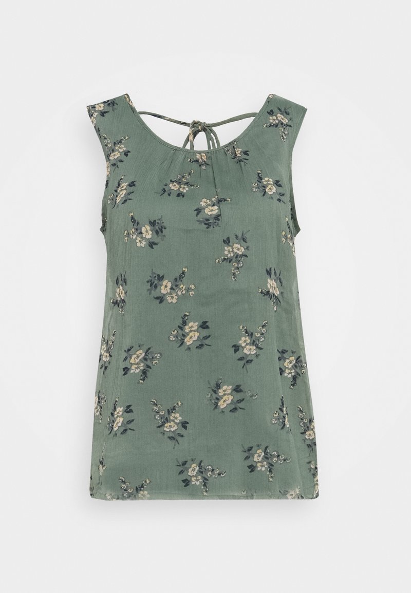 Blouse sans manches verte avec de petites impressions florales beiges et sombres, et un fin lien au niveau de l'encolure arrière.