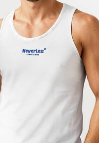 Weißes ärmelloses Tanktop aus glattem Stoff, mit einem blauen Logo, das "NeverLess" und den Satz "LA DOLCE VITA" trägt.