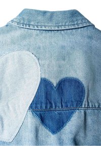 Veste en denim bleu clair vue de dos avec deux patchs en forme de cœur, l'un bleu foncé et l'autre blanc délavé, cousus et superposés.