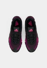 Čierno-ružové športové topánky majú strukturovaný dizajn s hornou časťou z sieťoviny, šnúrkami, hrubou podrážkou a výrazným logom na vnútornom chodidle.