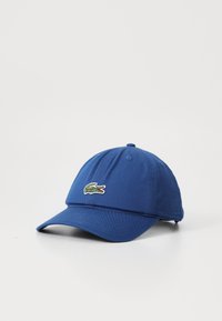 Casquette de baseball bleue en coton, avec une couronne ronde et un biberon incurvé, ornée d'un logo de crocodile vert brodé à l'avant.